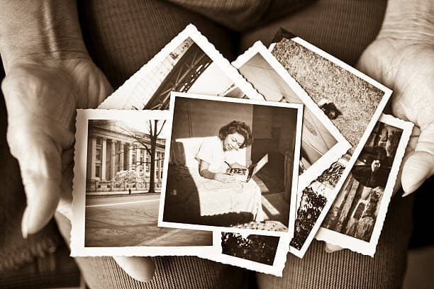 Hands holding a stack of old prints